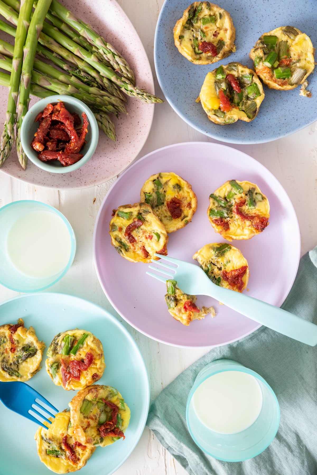 Baby Frittatas on servings plates with ingredients surrounding them.