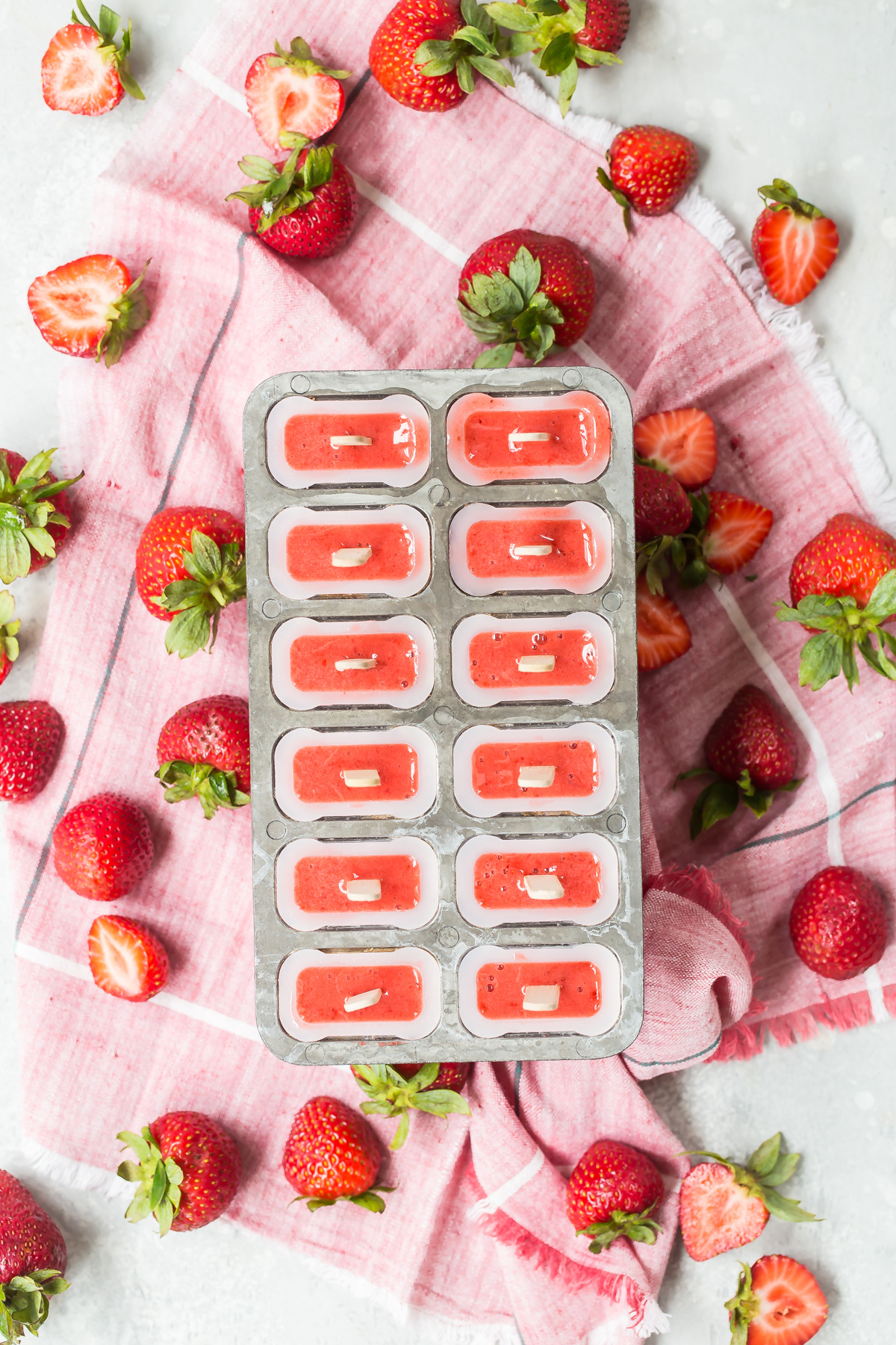 Strawberry popsicles in popsicle molds.