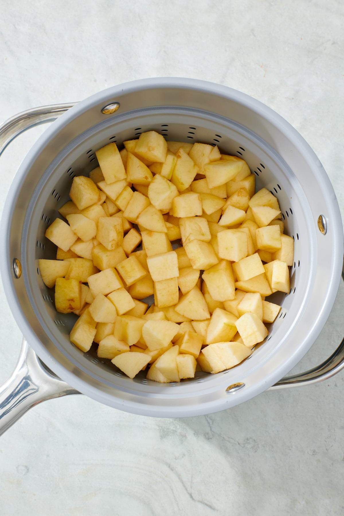 Chopped apples in steamer pot.