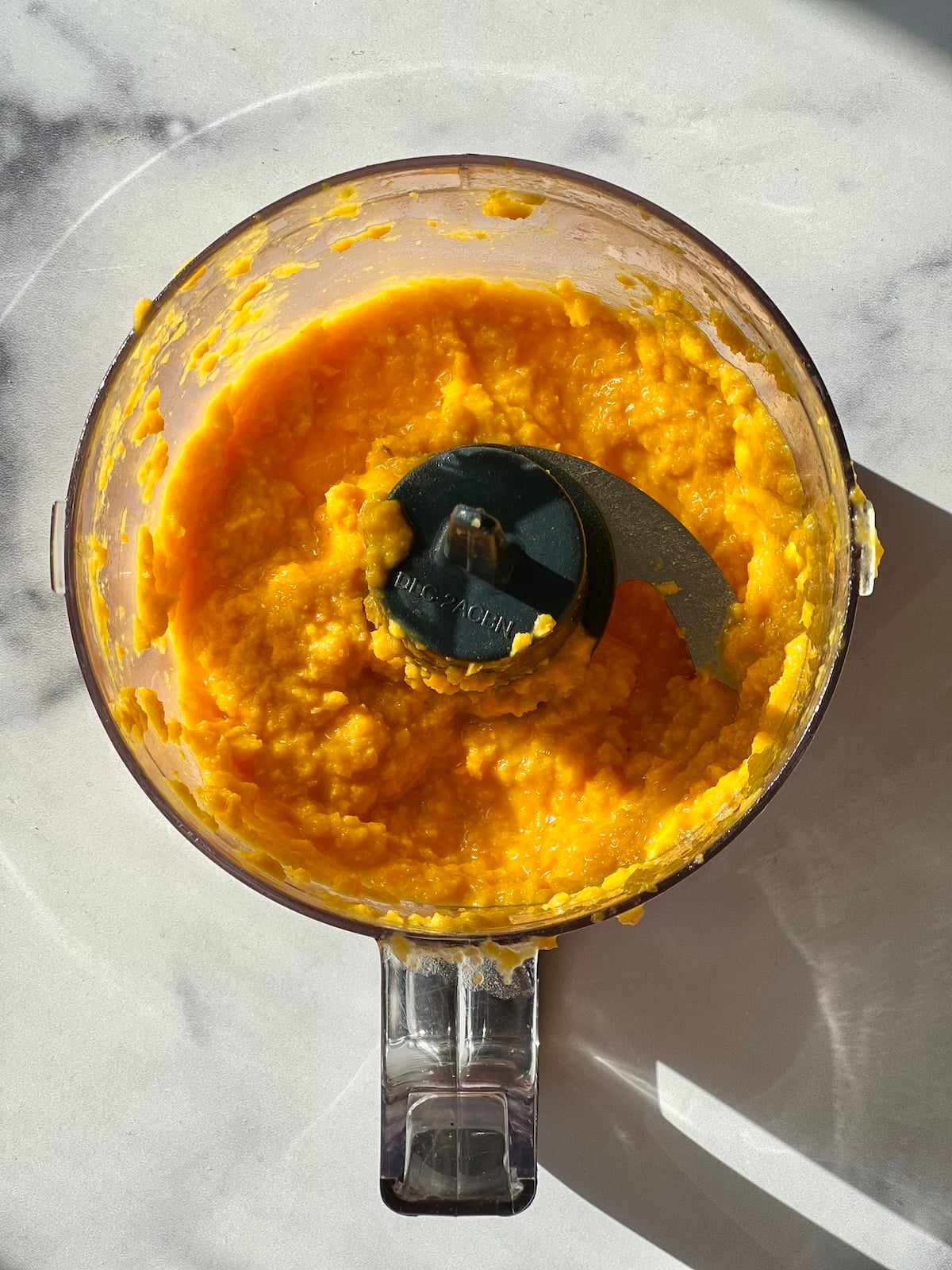 Pureed carrot ginger miso dressing in food processor.