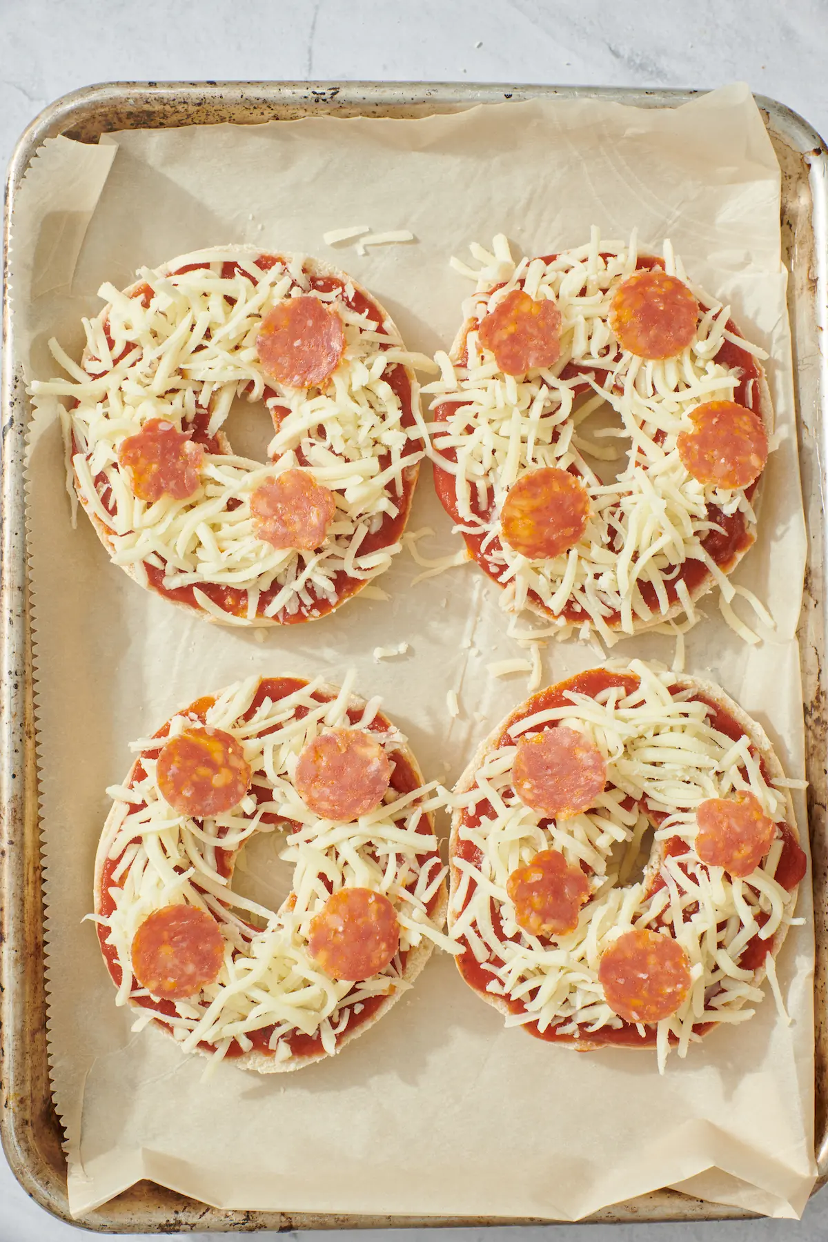 pepperoni and shredded cheese on top of bagels
