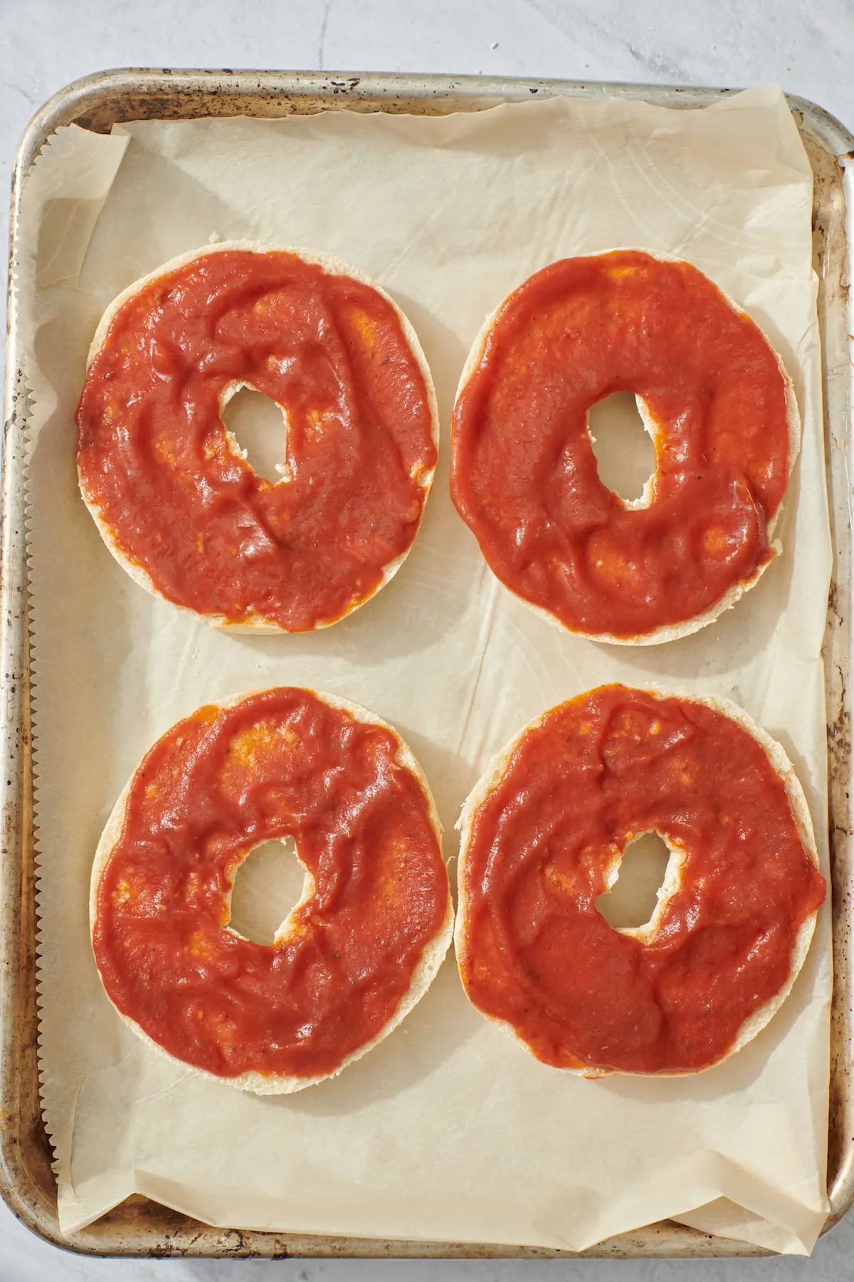 bagels coated with pizza sauce