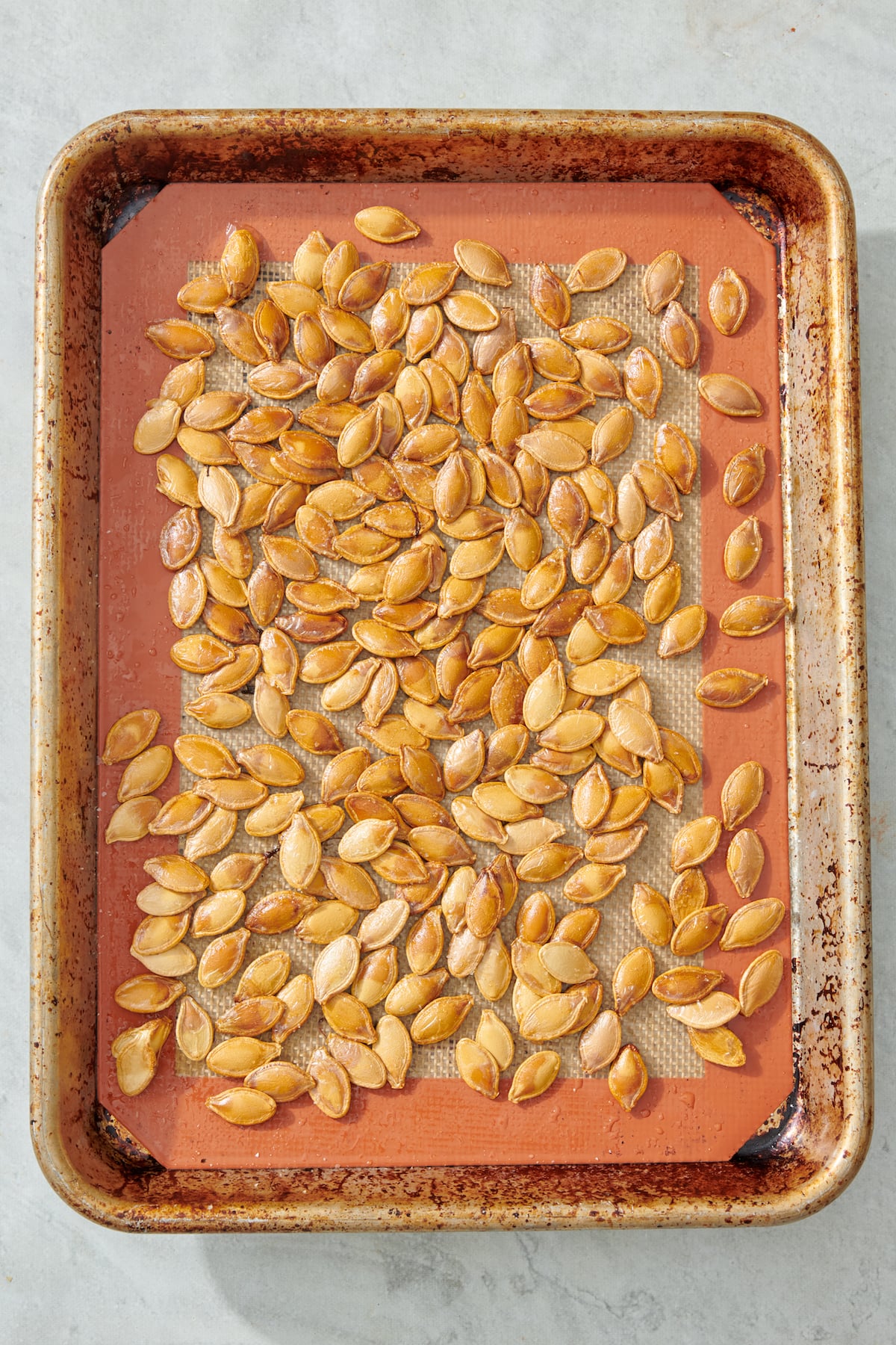 Toasted pumpkin seeds on baking sheet.