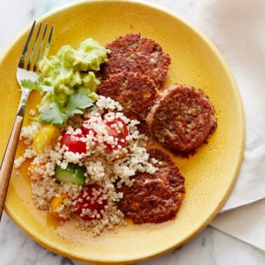 Black bean cakes on plate served with quinoa salad.