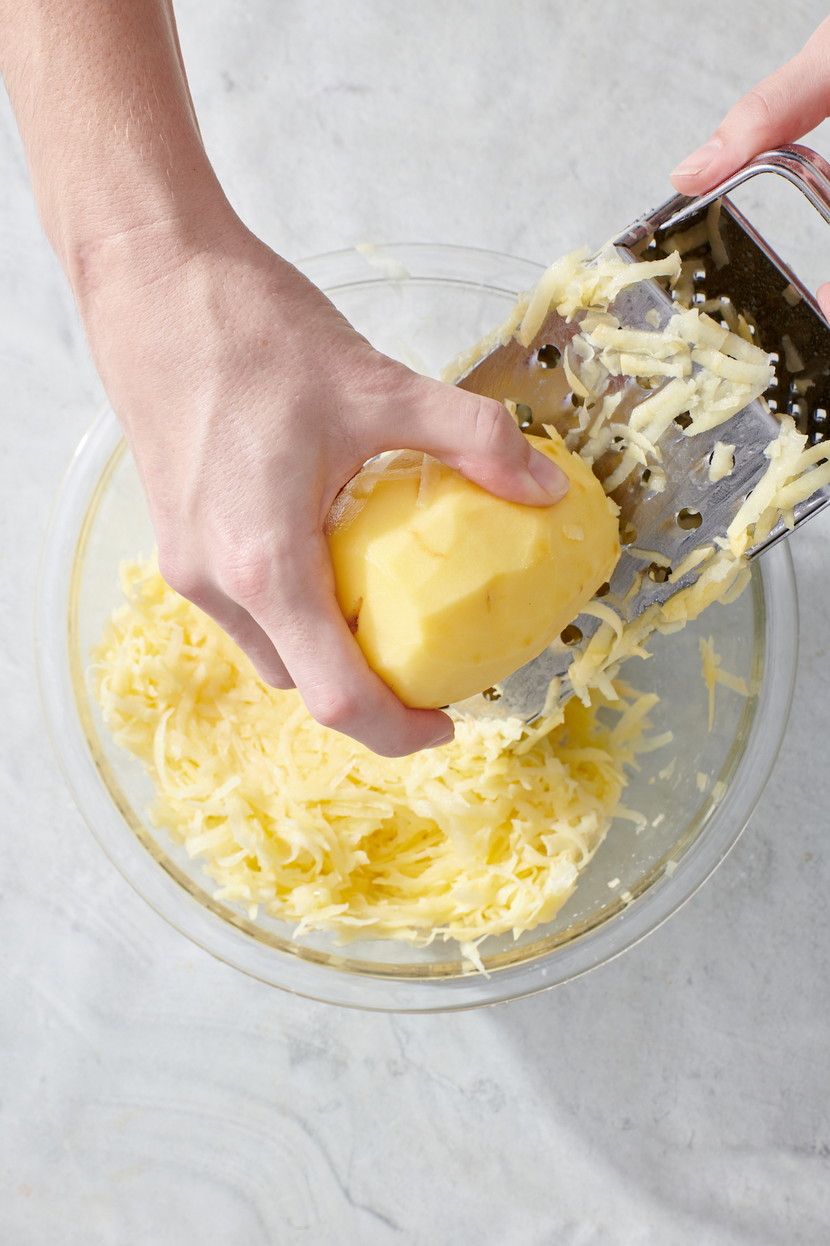 Grating a potato on a box grater.