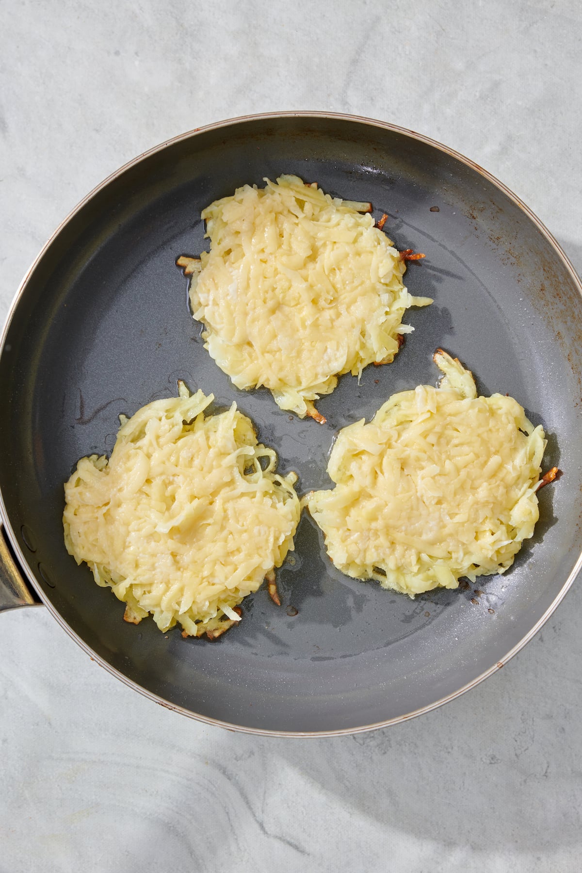Latkes in saute pan ready to be flipped.