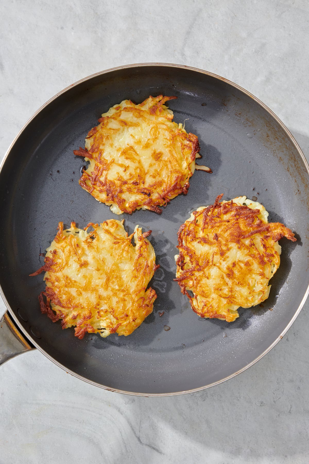 Latkes in saute pan.