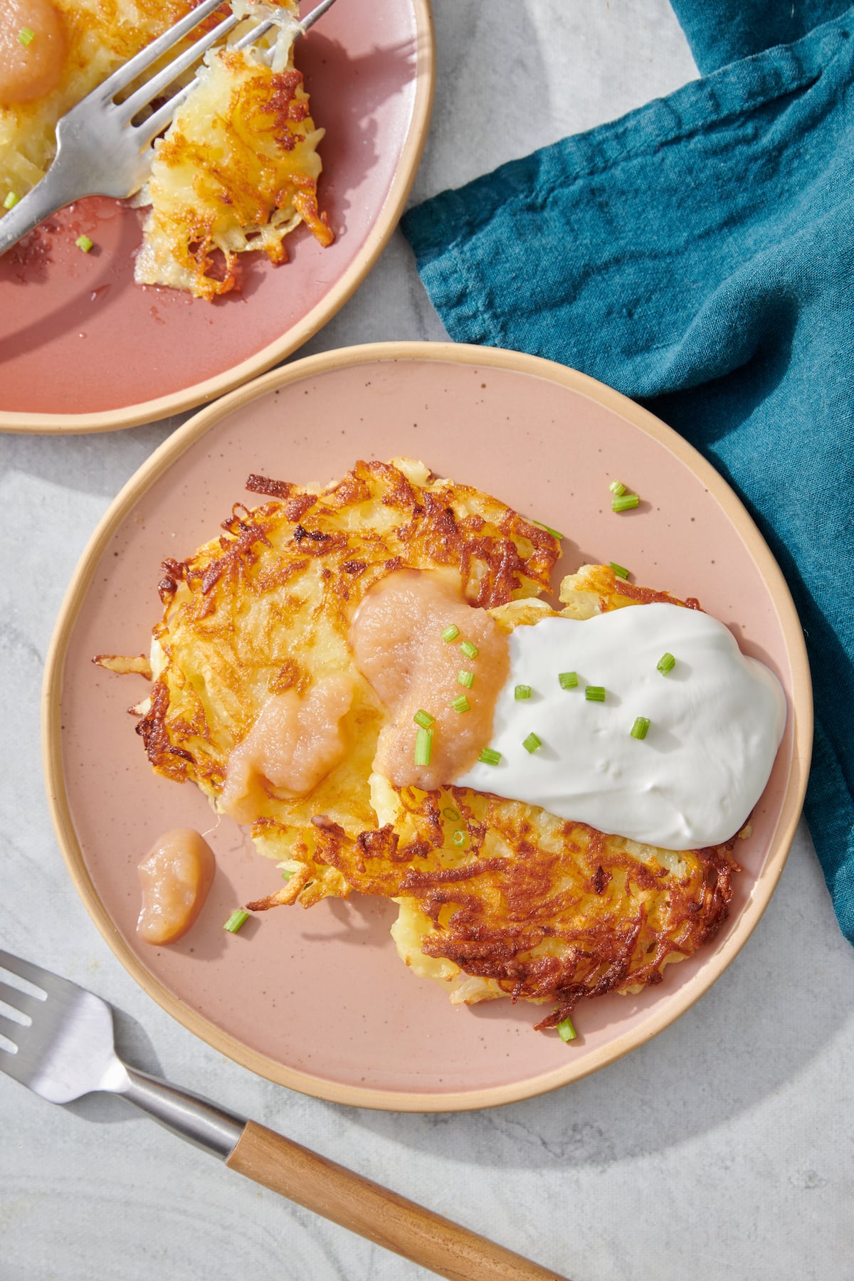 Latkes topped with sour cream and applesauce.