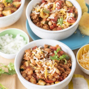 Turkey veggie chili in bowls with toppings.