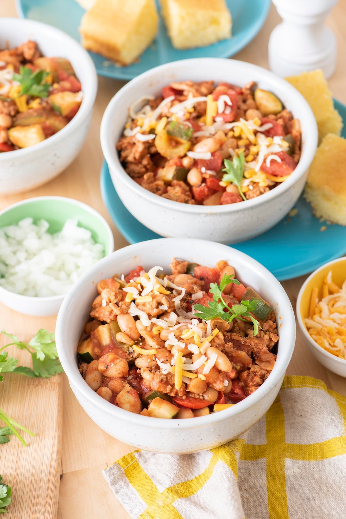 Turkey veggie chili in bowls with toppings.