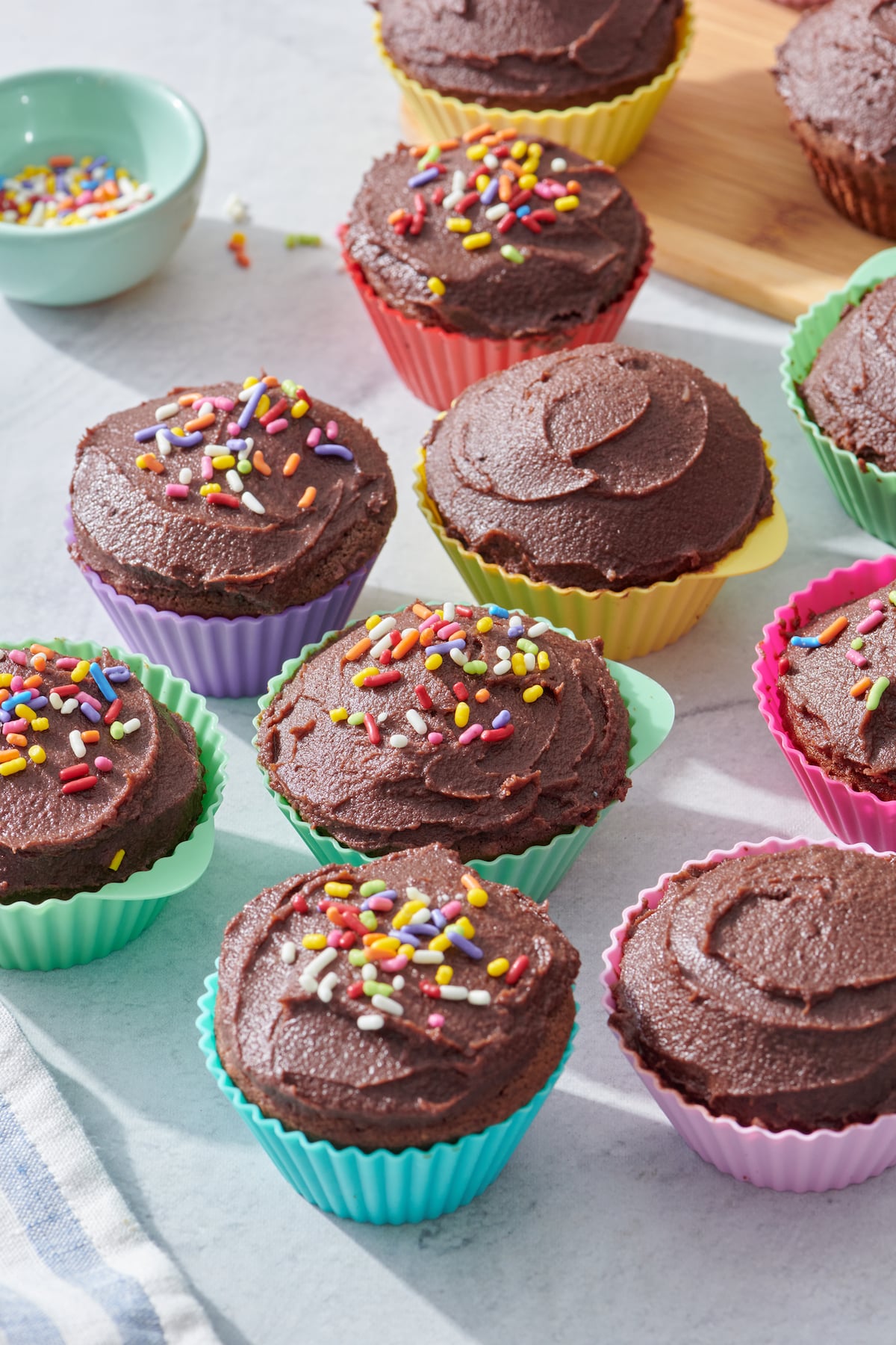 dark chocolate cupcakes with chocolate ganache decorated with rainbow sprinkles
