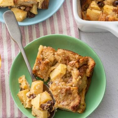 Serving of breakfast bread pudding on green plate.