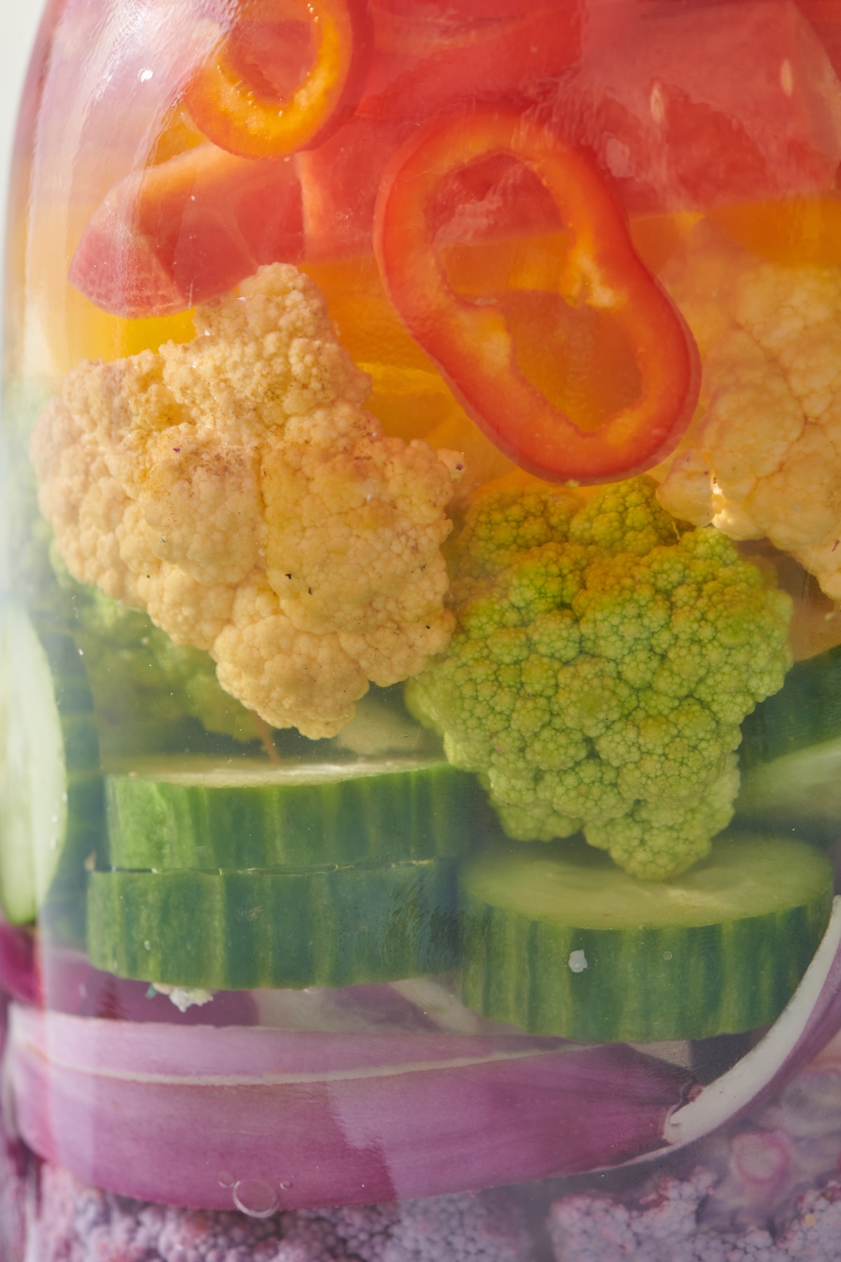 Purple onions, cucumbers, cauliflower and bell peppers pickling in brine.