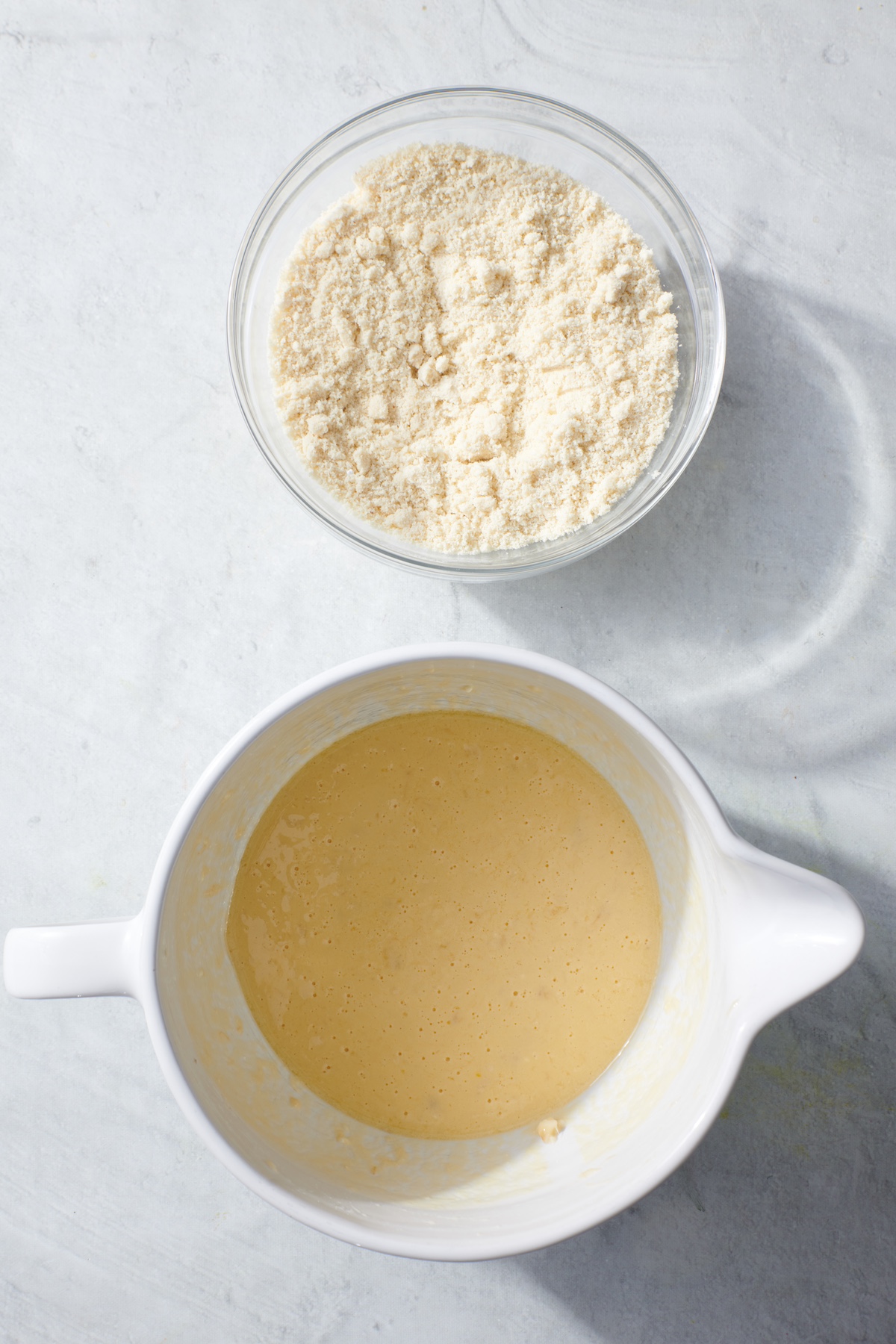 Mixing bowl with combined dry ingredients and a separate mixing bowl with combined wet ingredients.