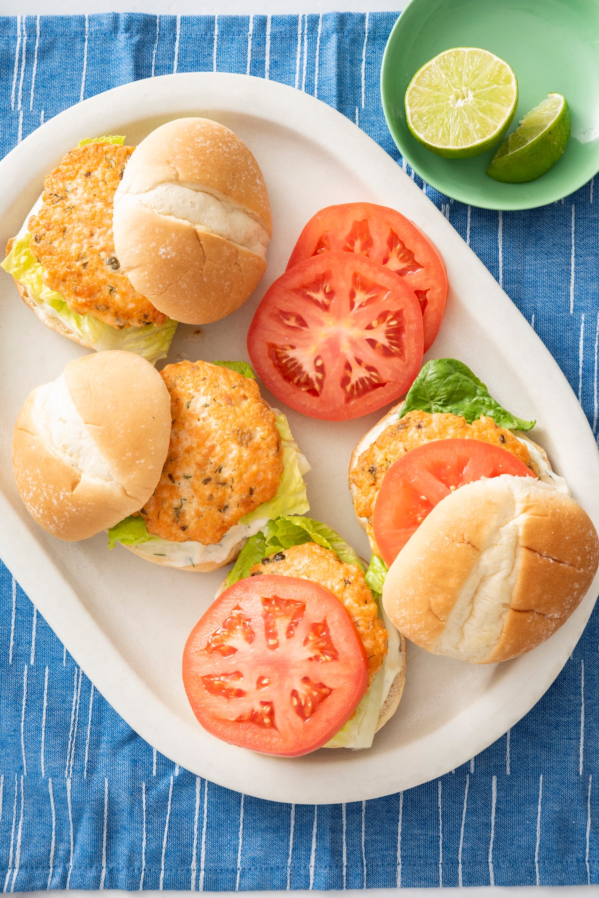 Overhead view of 4 salmon burgers on a serving plate.