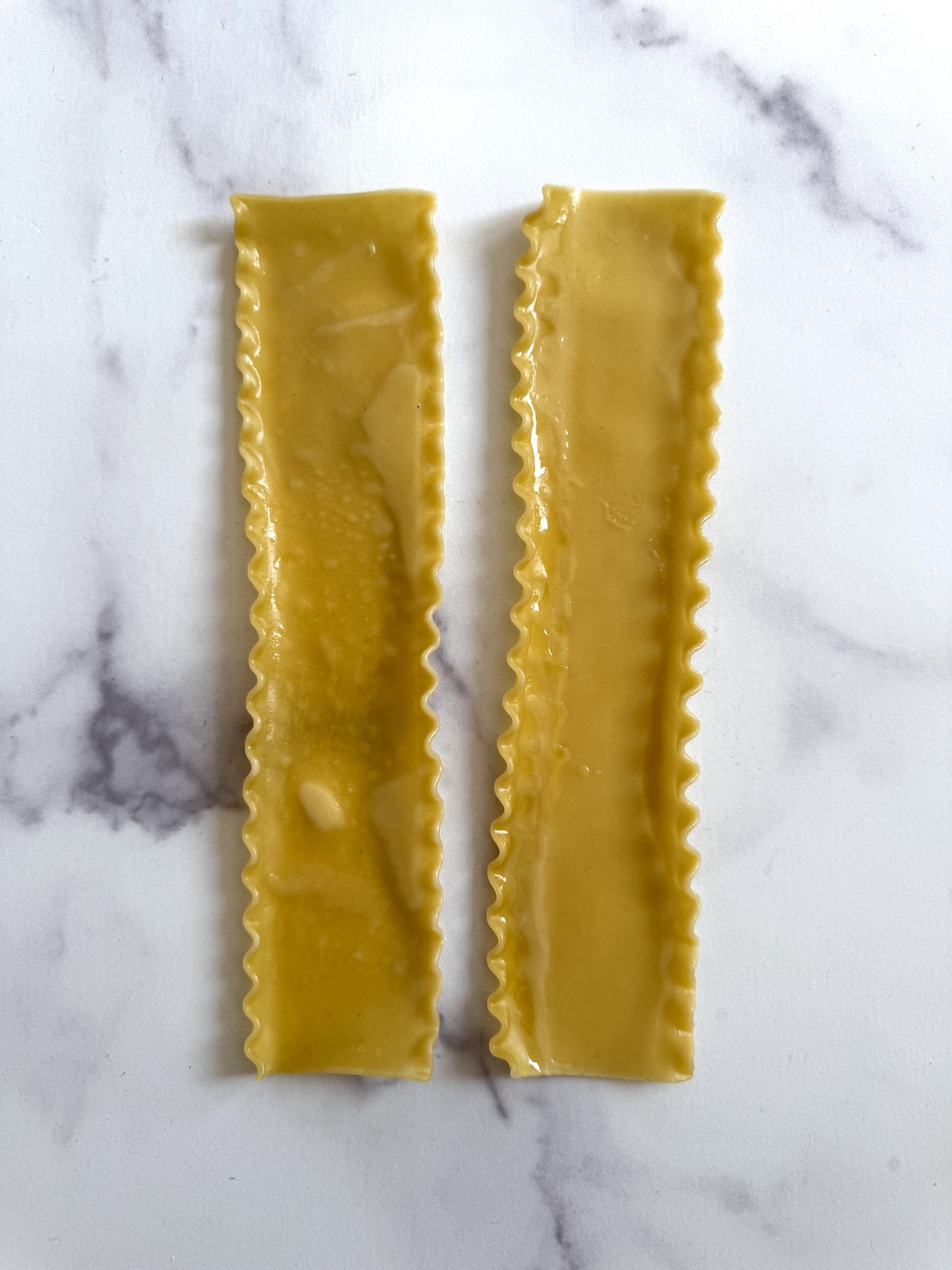 Cooked lasagna noodles on a surface.