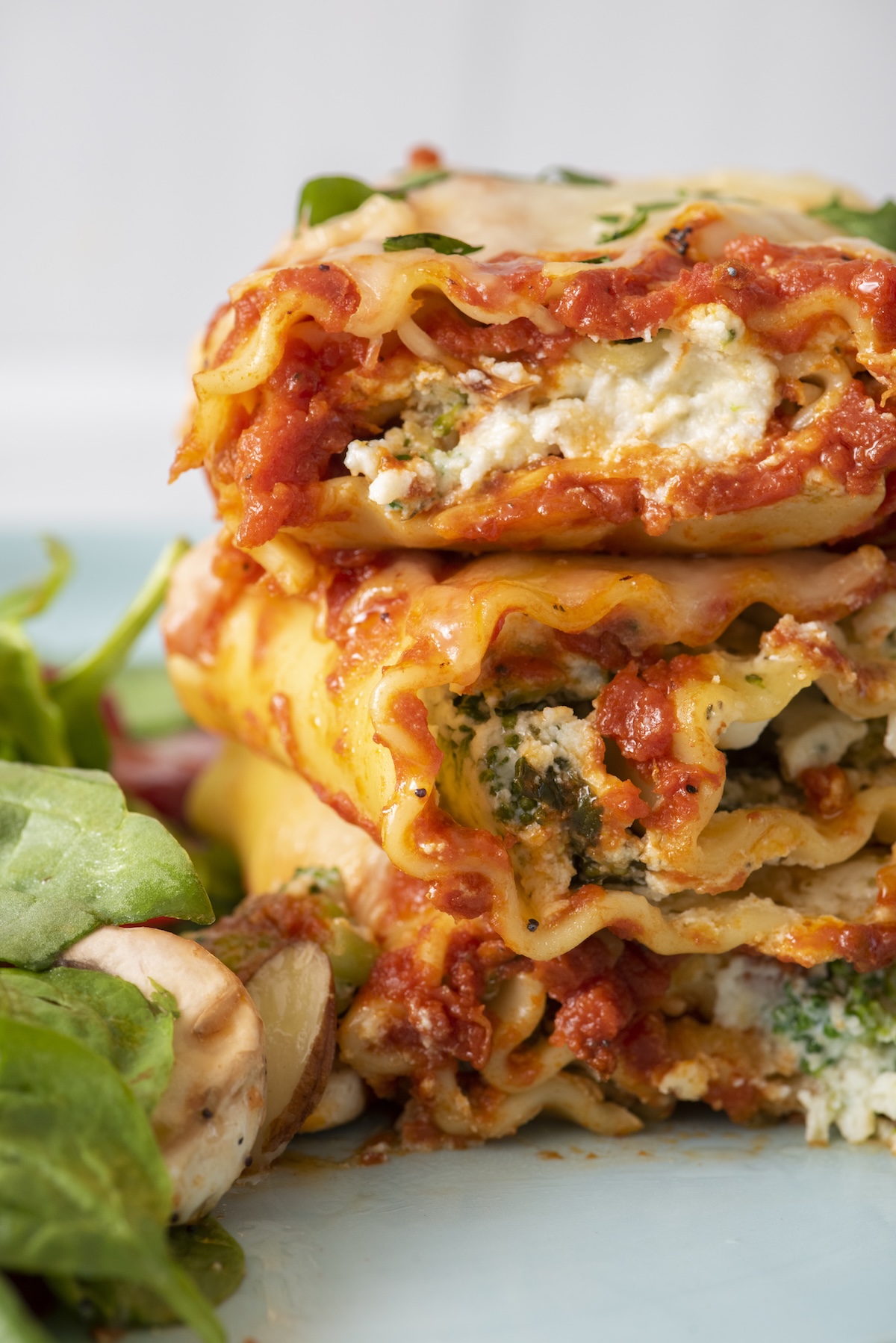 Lasagna rolls stacked on top of each other on a plate.