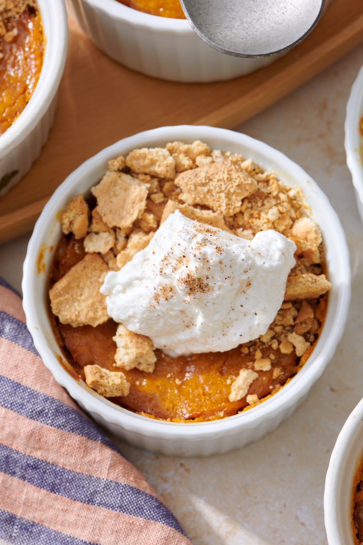 Mini Pumpkin Cheesecake topped with whipped cream and crushed graham crackers.