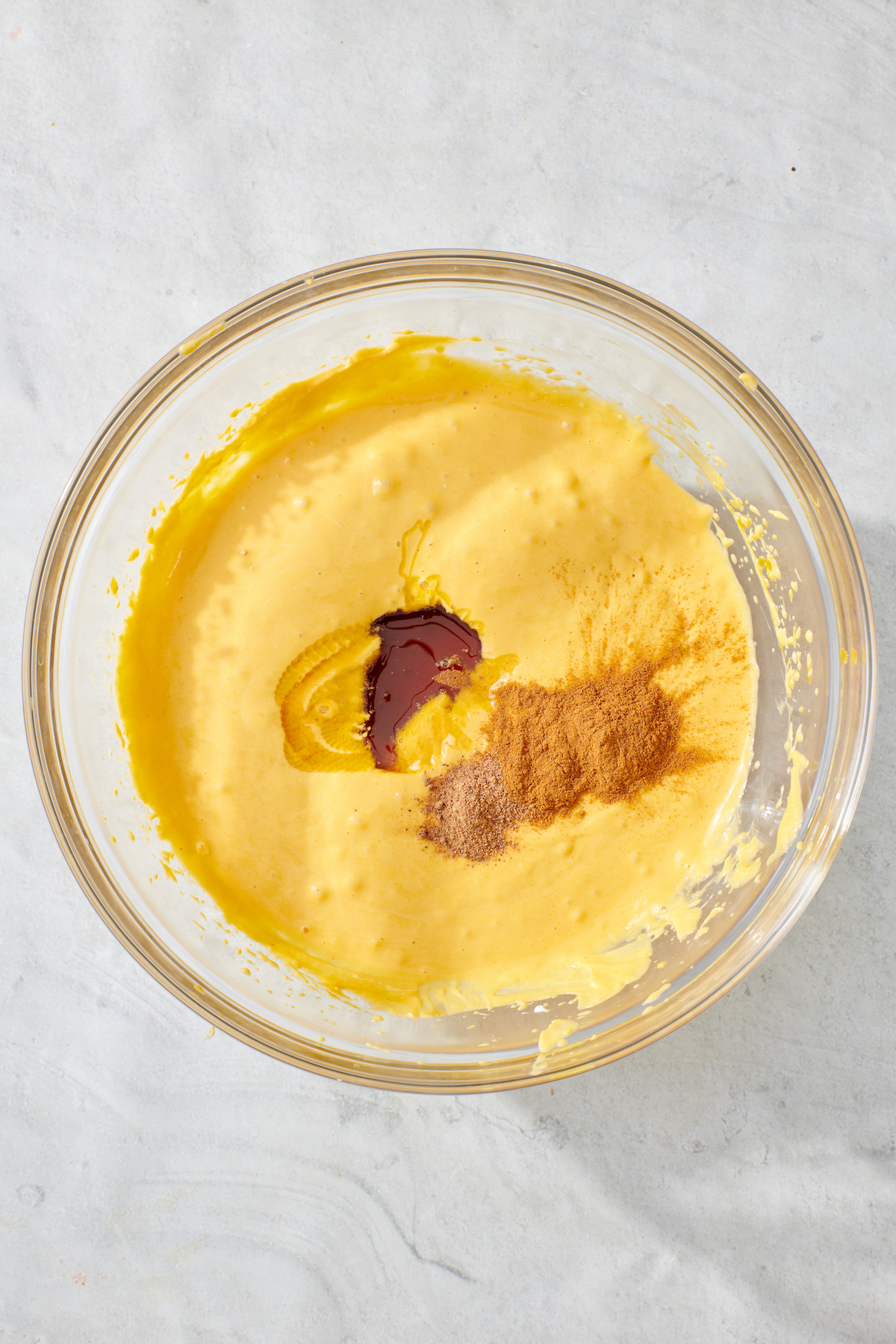 Pumpkin puree and whipped cream mixture with honey, cinnamon and nutmeg in mixing bowl before being combined.