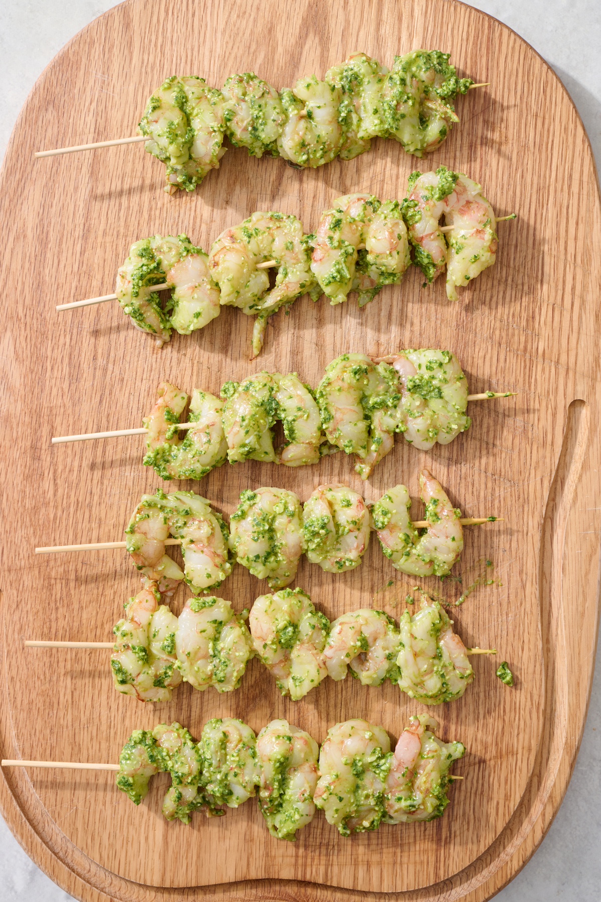 Raw shrimp threaded on skewers.