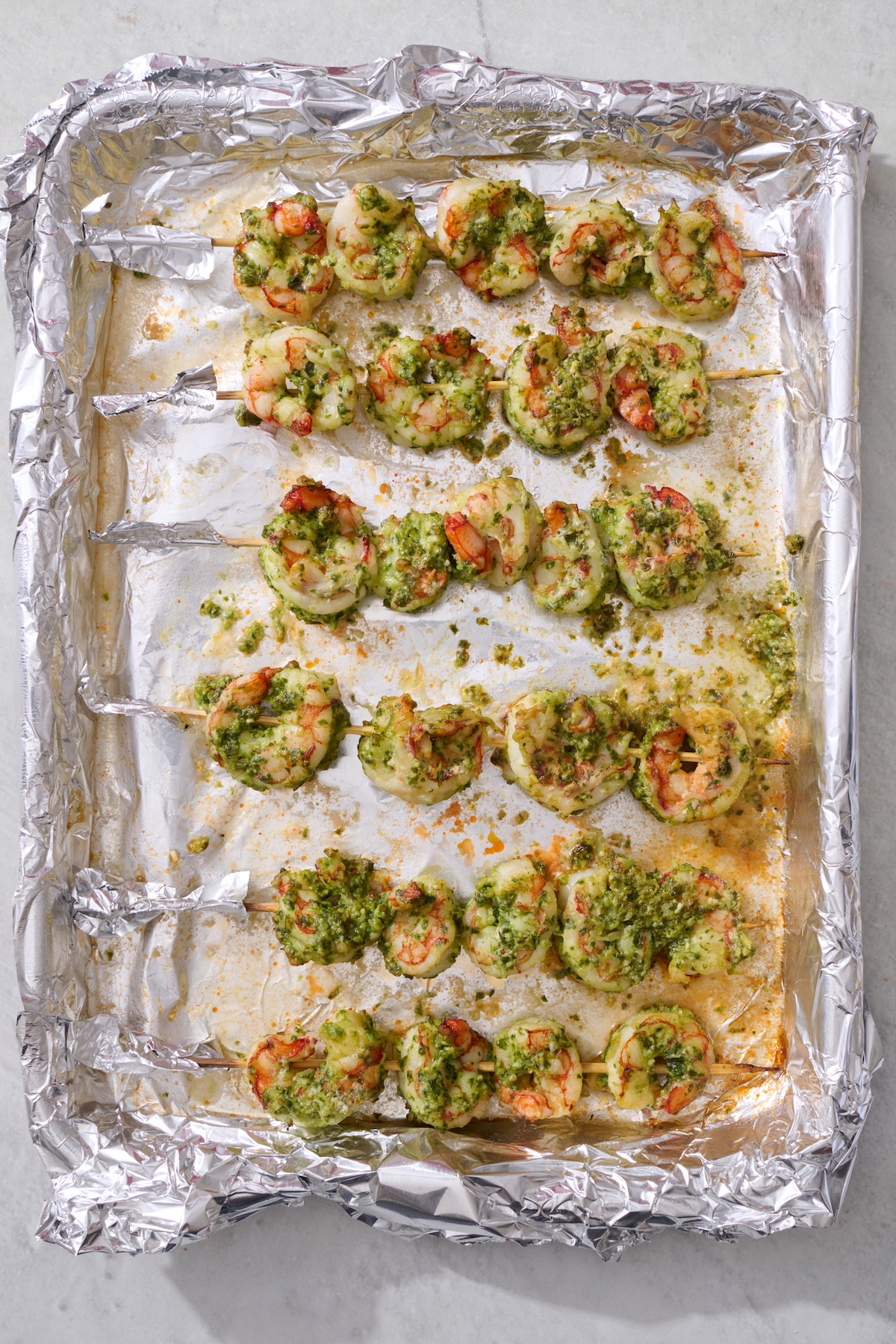 Shrimp skewers on baking sheet after being broiled.