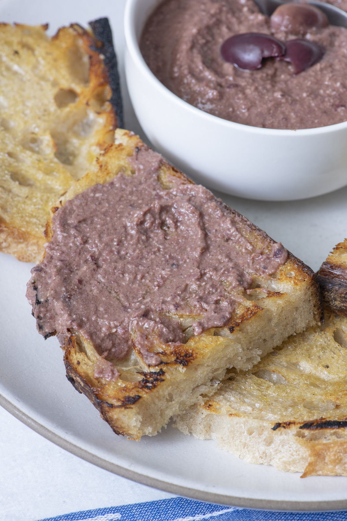 Olive tapenade on piece of crispy bread.