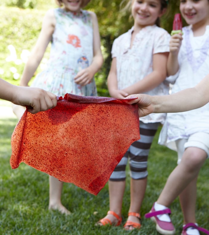 Kids with a sheet of Strawberry Fruit Leather.