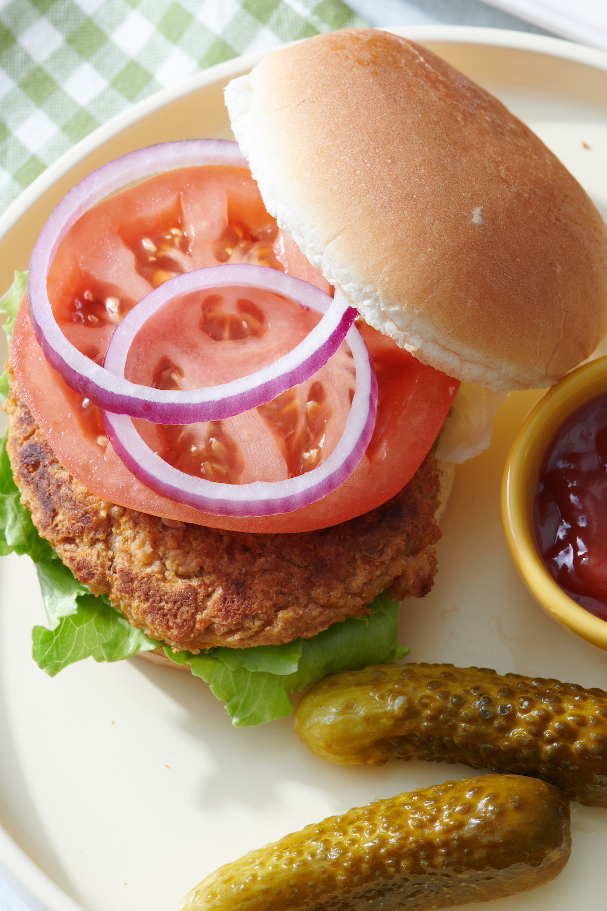 Veggie burger with tomato, red onion and lettuce on a plate.