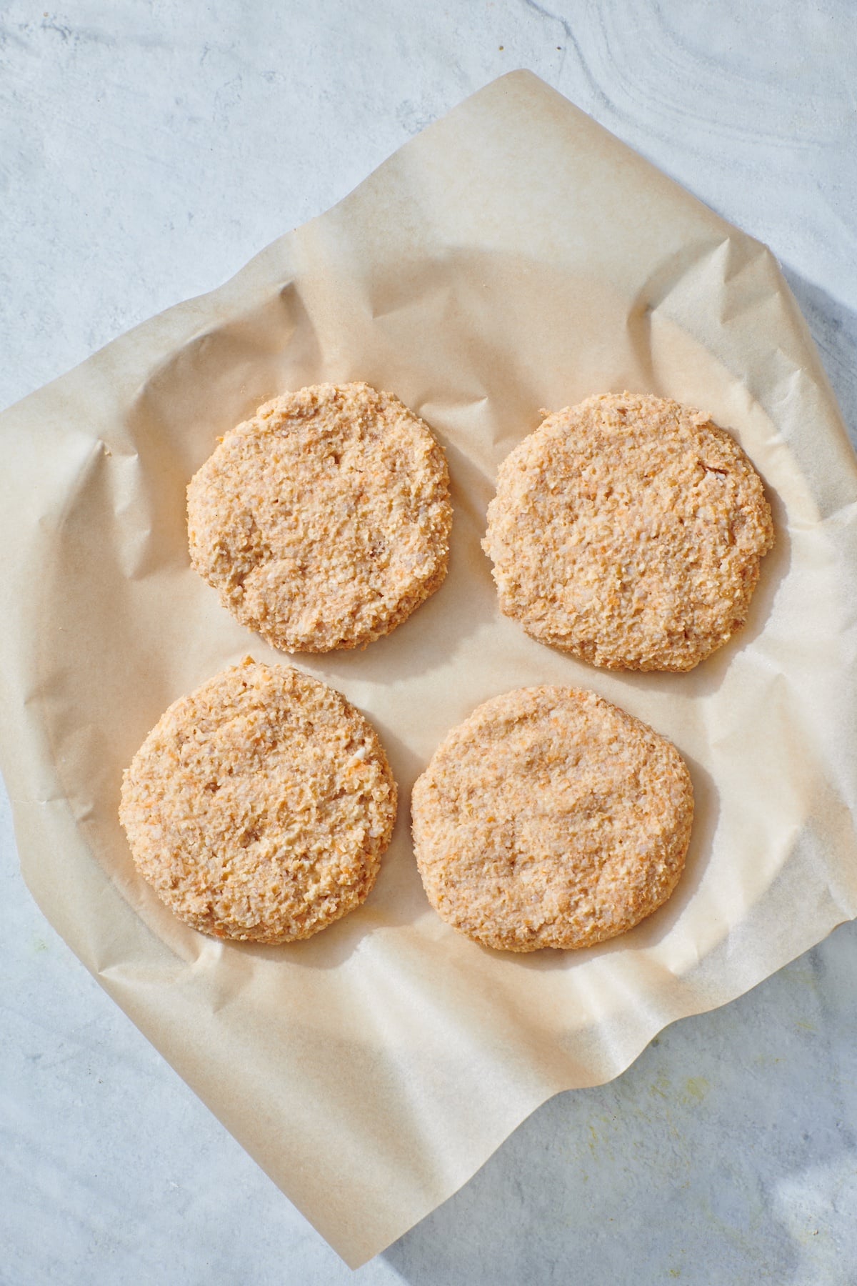 Four veggie burger patties on plate before being cooked.