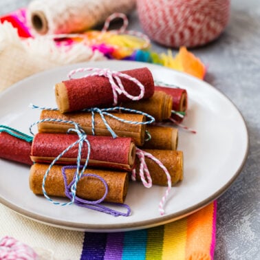 Fruit leather rolled up and placed on a plate.