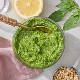 Basil pesto in bowl with spoon.