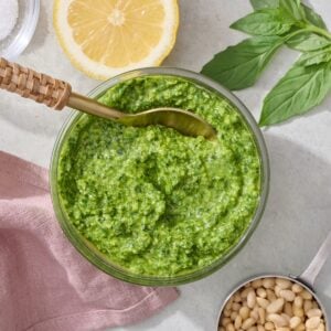 Basil pesto in bowl with spoon.