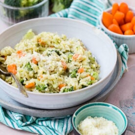 Carrot broccoli and cheese orzo in a serving bowl.