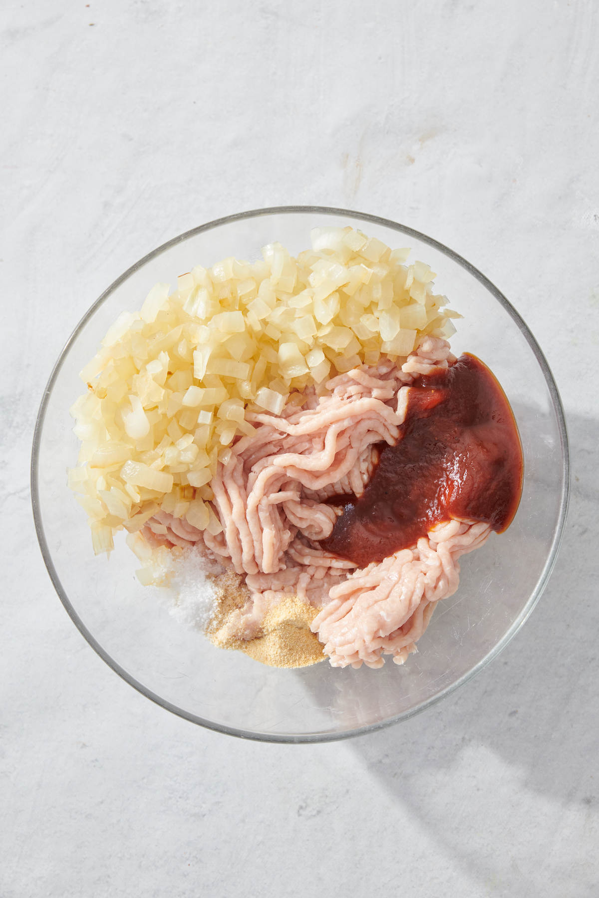 Sautéed onions, ground chicken, BBQ sauce and spices in a bowl