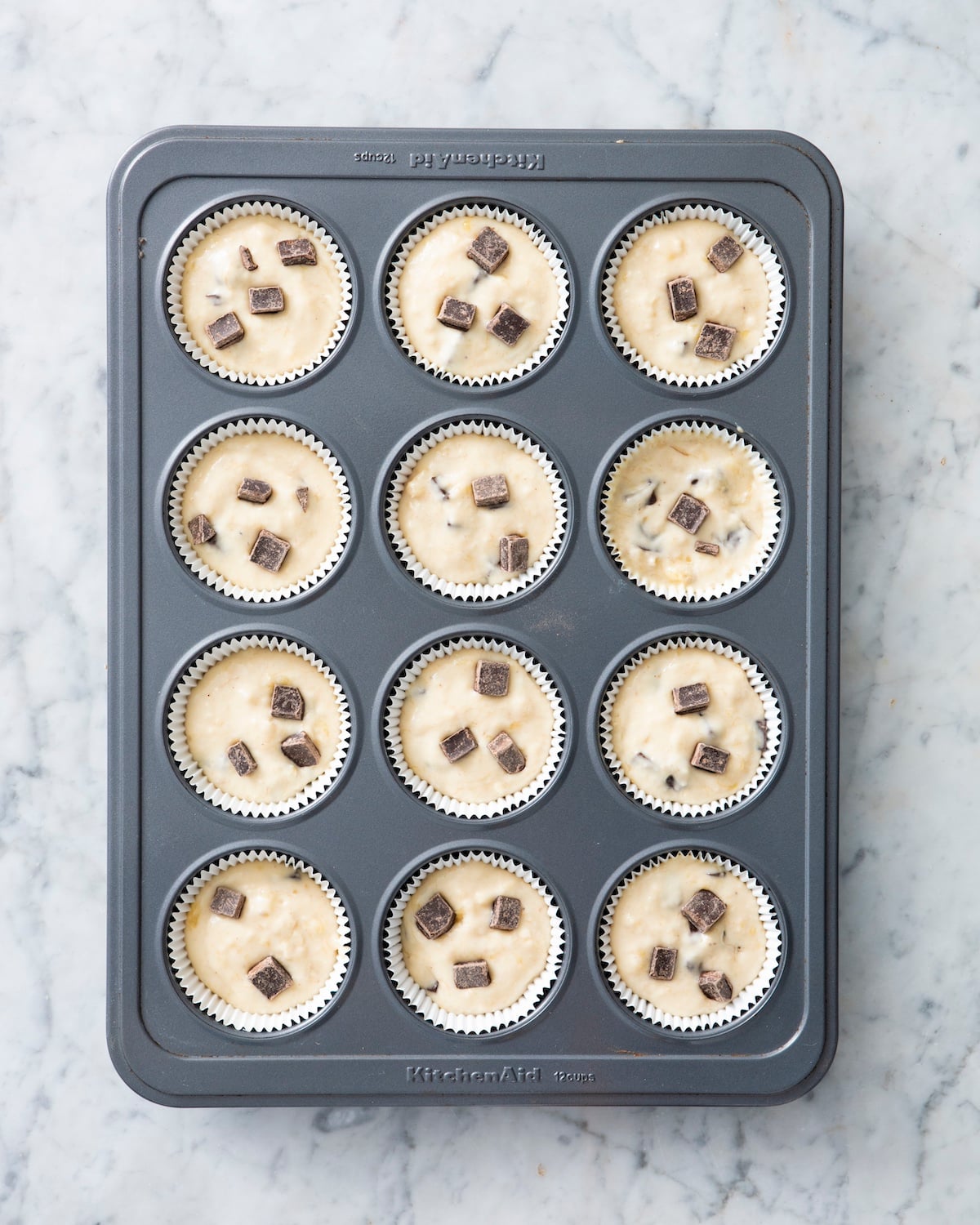 Banana chocolate chip muffins in muffin tin.