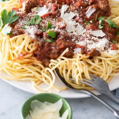 Crock pot meaty pasta sauce on top of spaghetti noodles.