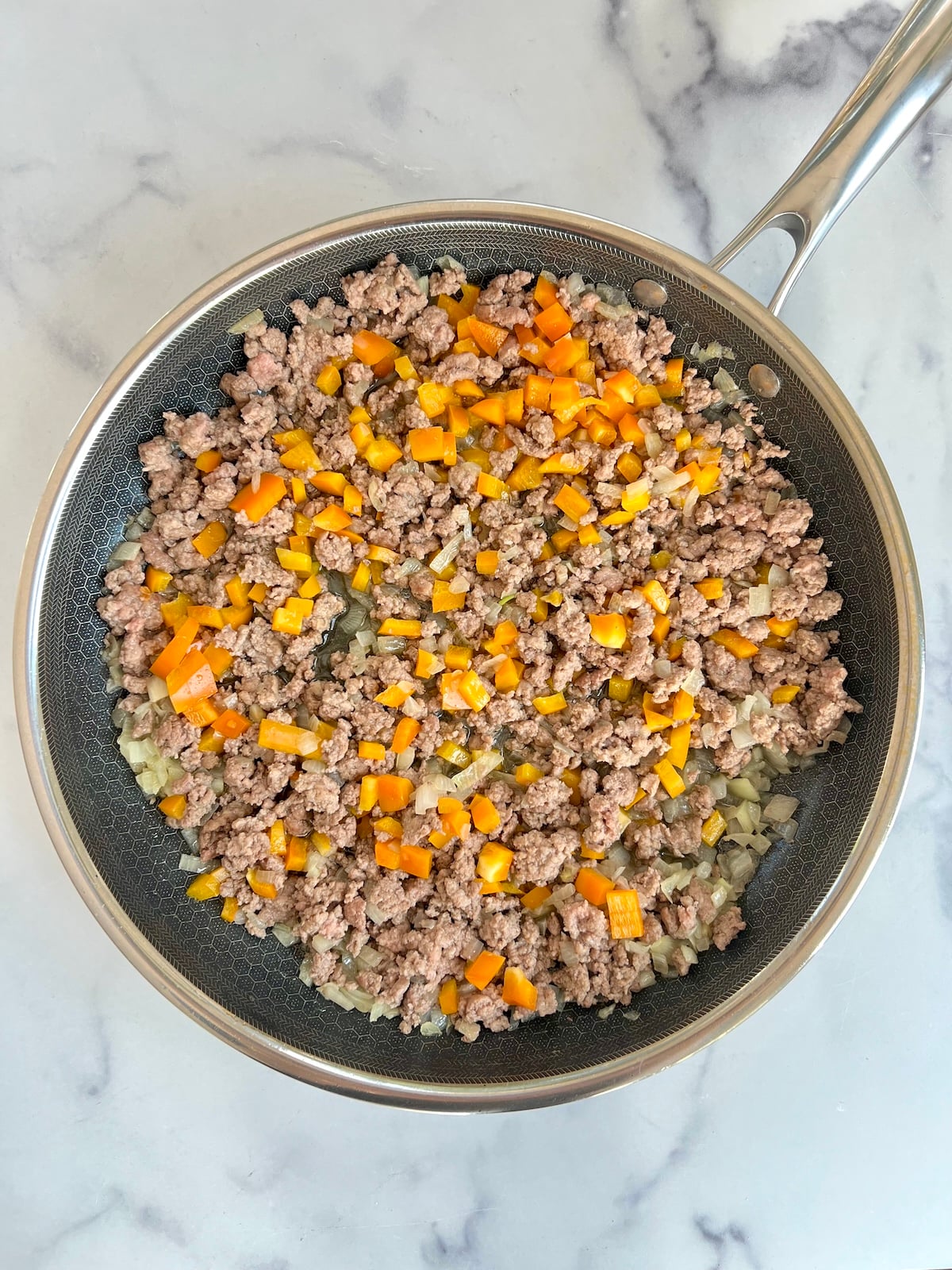 Sauteed ground beef and vegetables in a pan.