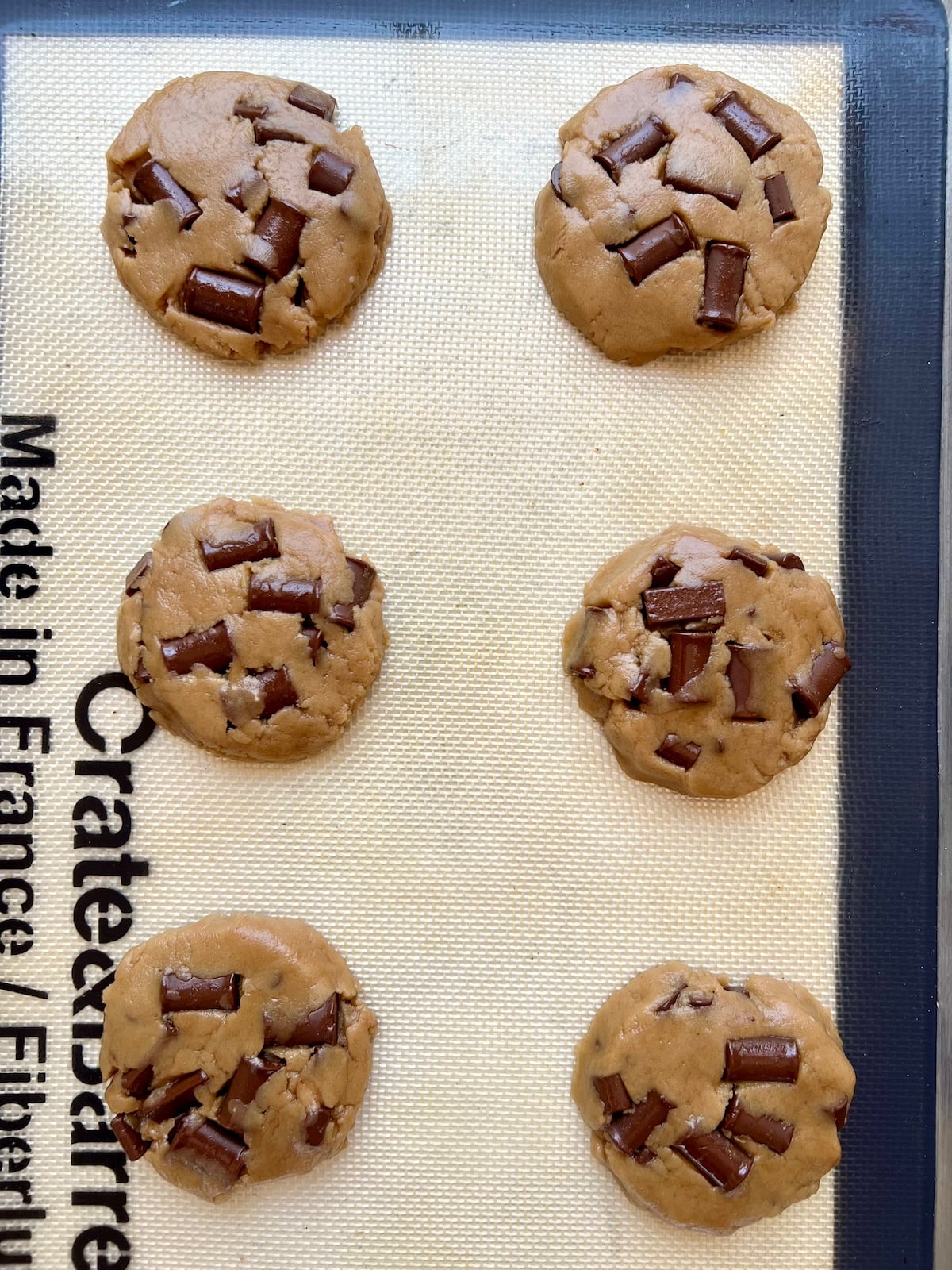 Unbaked vegan chocolate chip cookies on baking sheet.