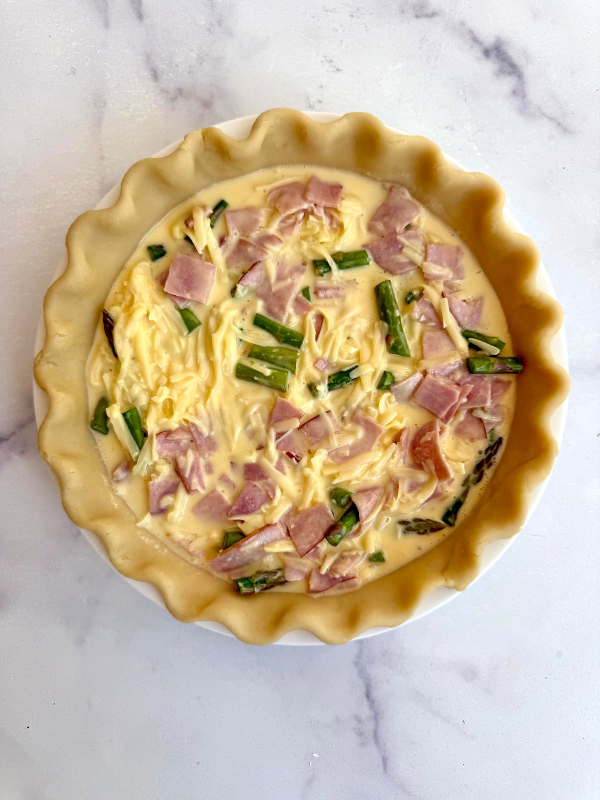 Ham and asparagus quiche before baking.