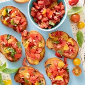 Tomato bruschetta on a blue serving platter.