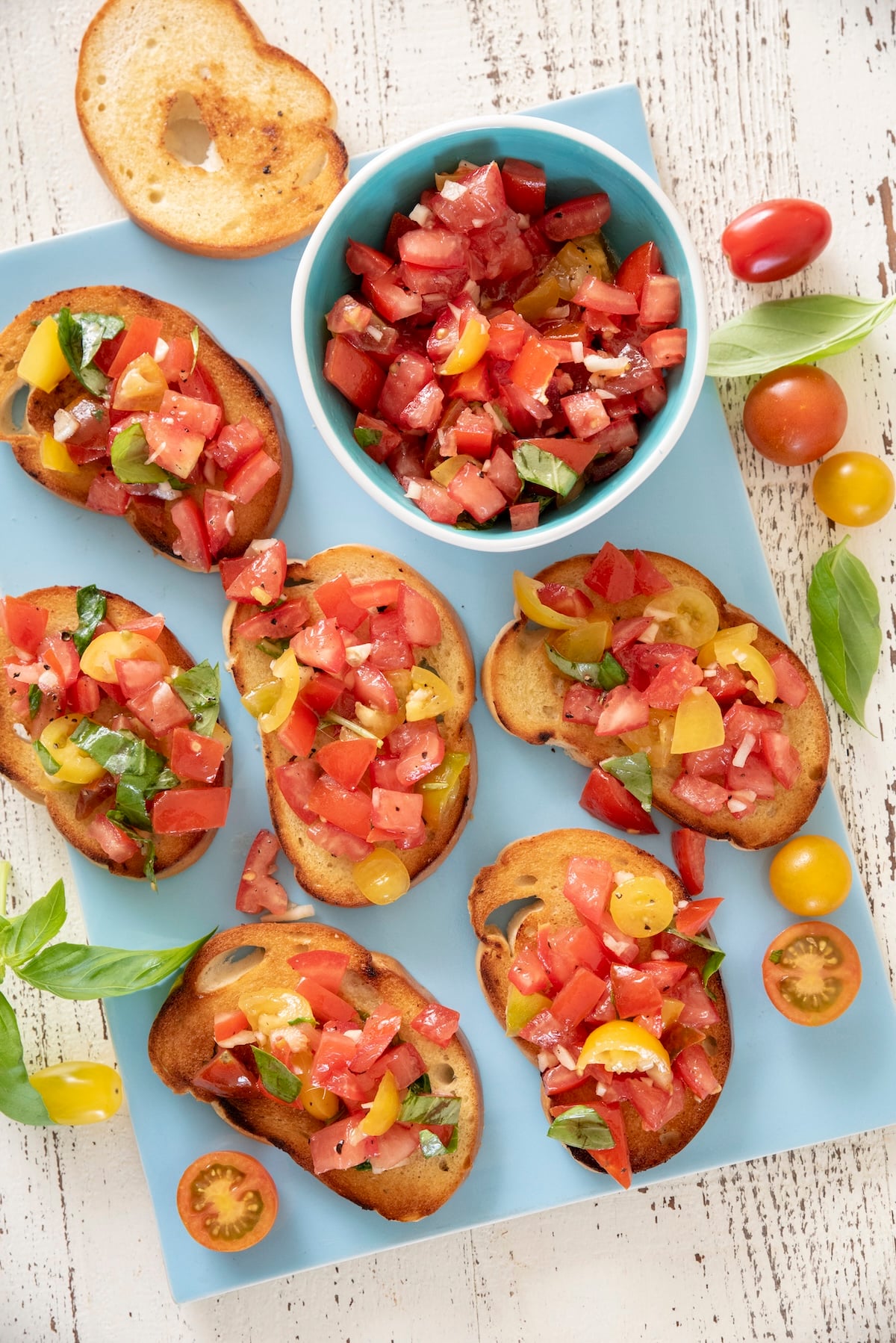 Tomato bruschetta on a blue serving platter.