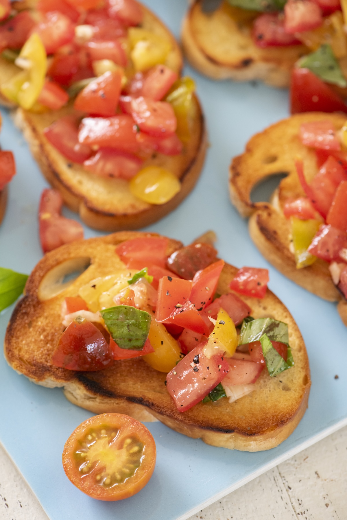 Tomato bruschetta on a blue plate.
