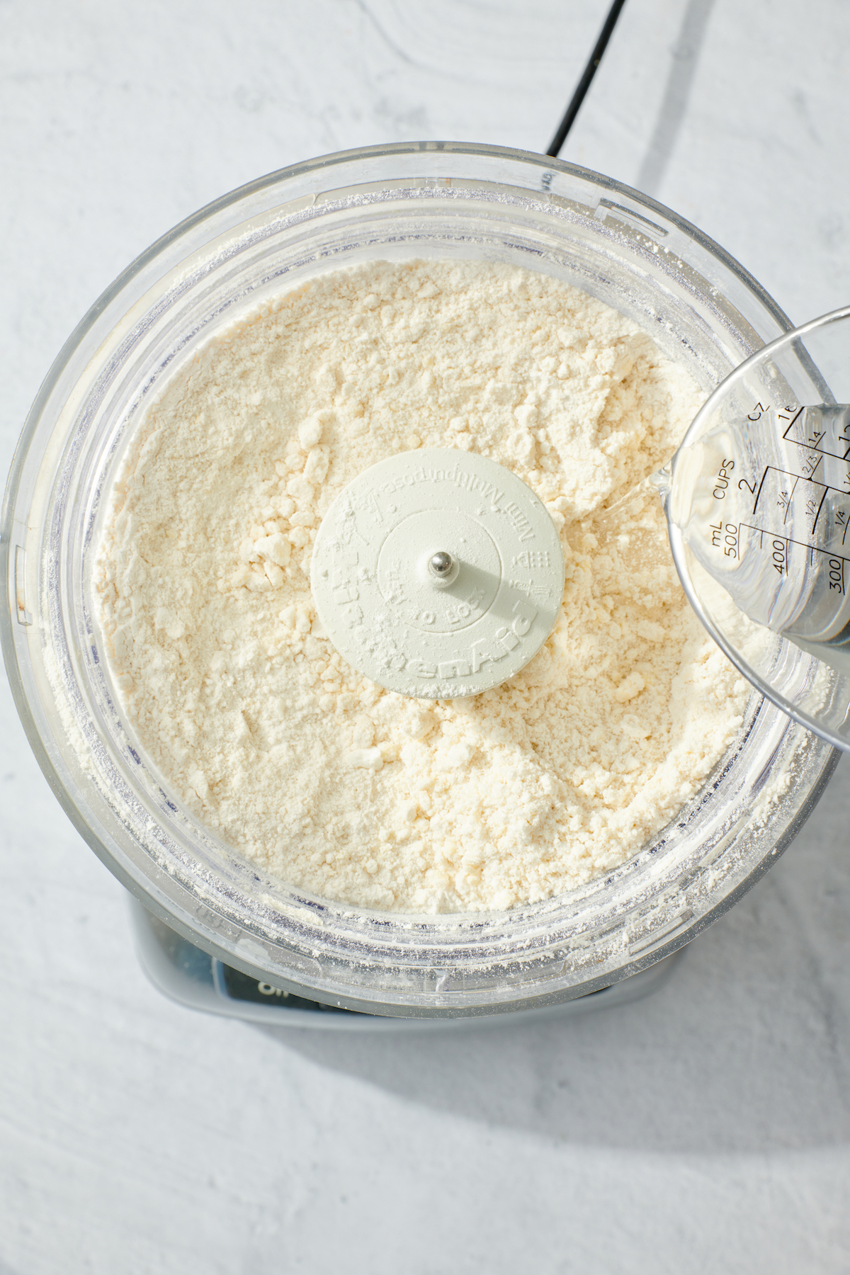 Adding water to pie dough.