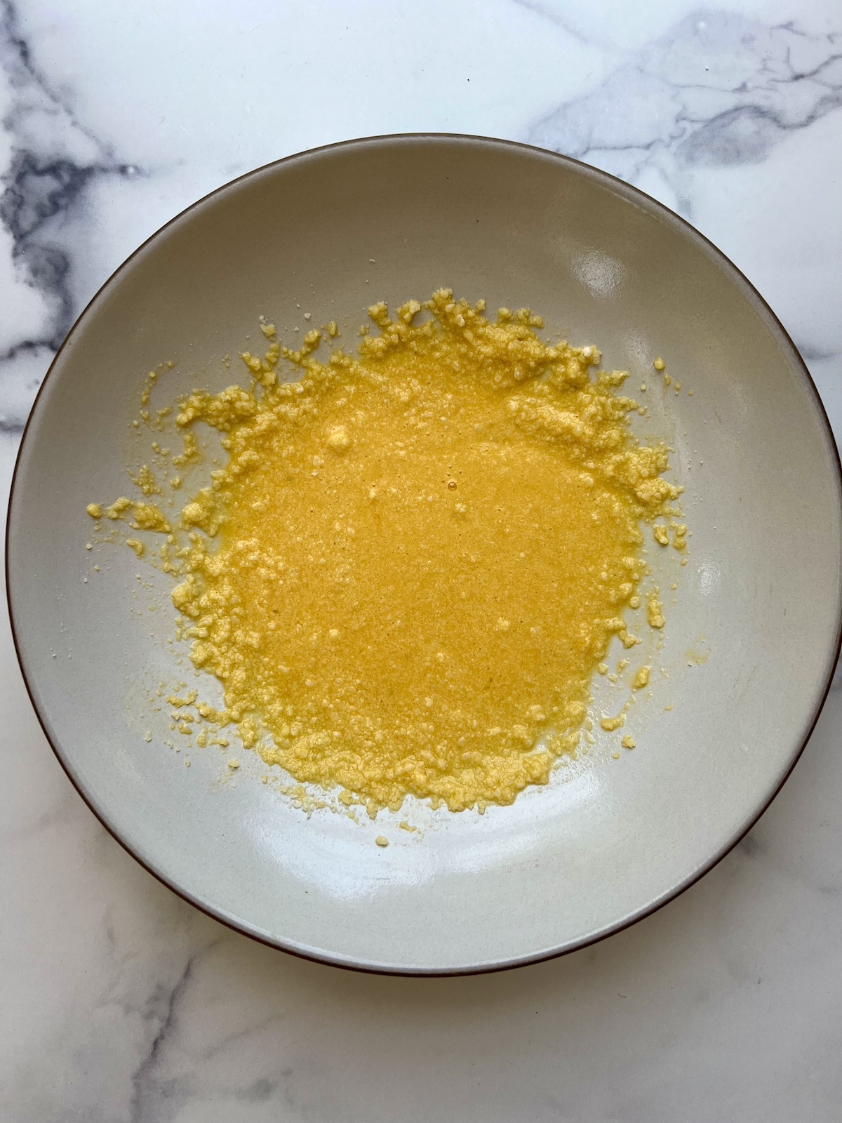 Whisked eggs and grated parmesan cheese in a bowl.