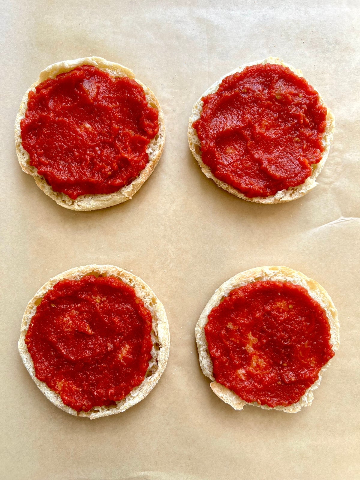 English muffins topped with pizza sauce.