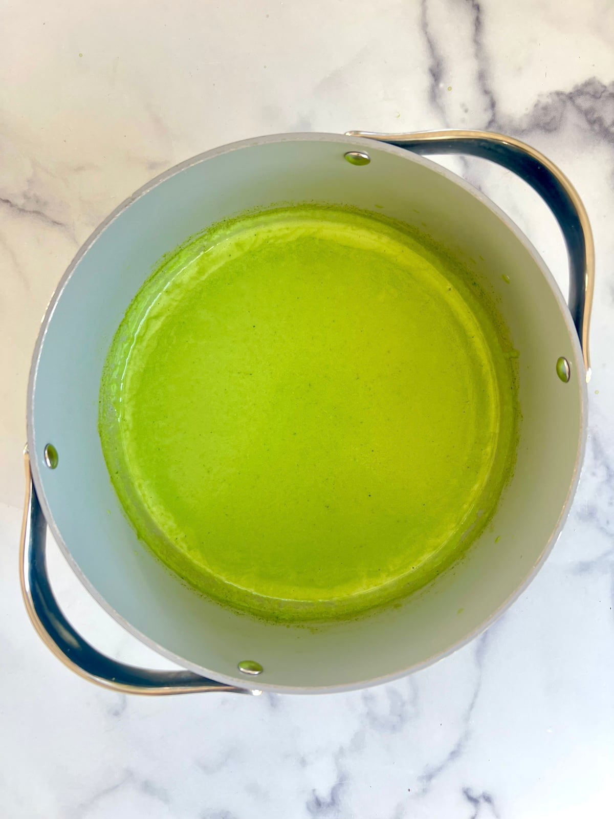 Green macaroni and cheese roux in a sauce pan.