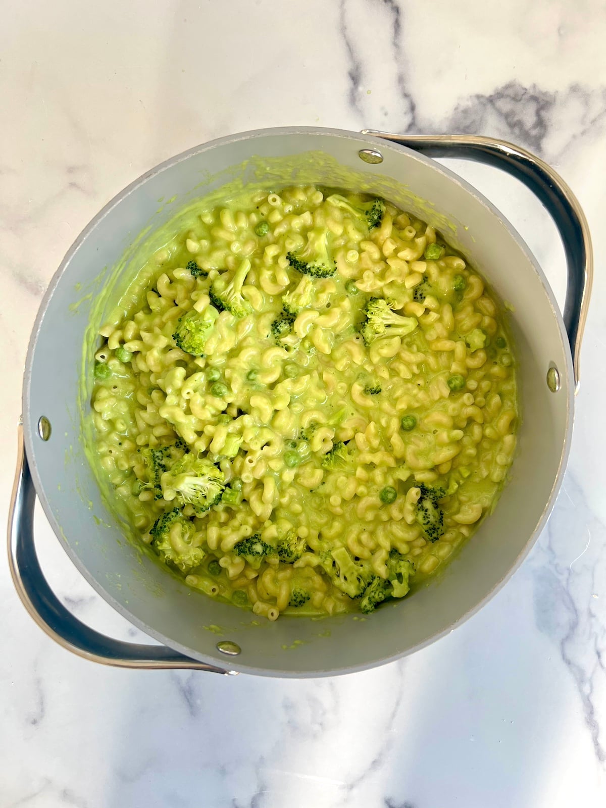 Green mac and cheese in a pot before baking.