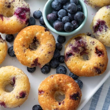 Baked blueberry doughnuts on a platter.
