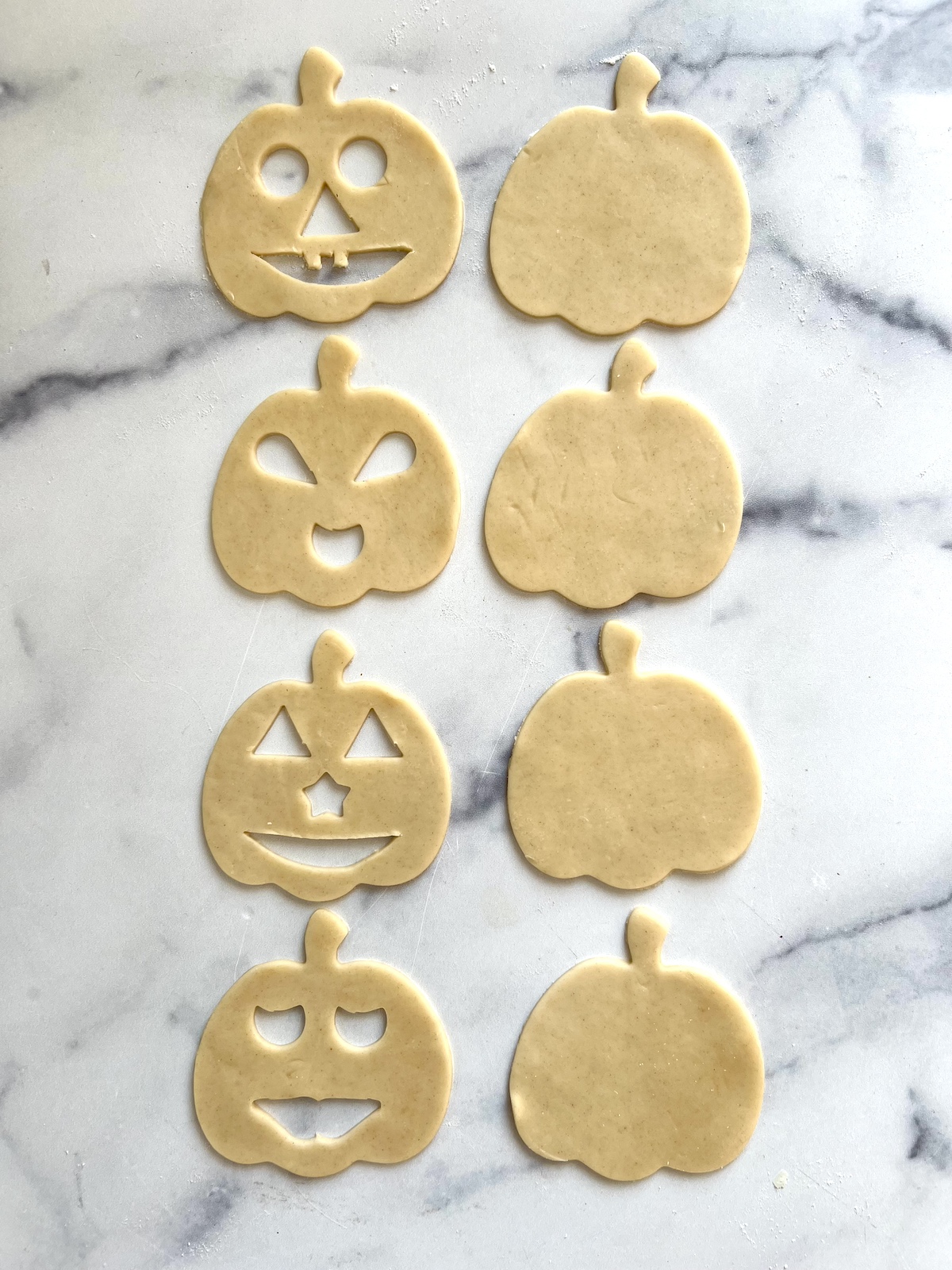 Pumpkin cutouts. Half with jack-'o-lantern faces and half without.