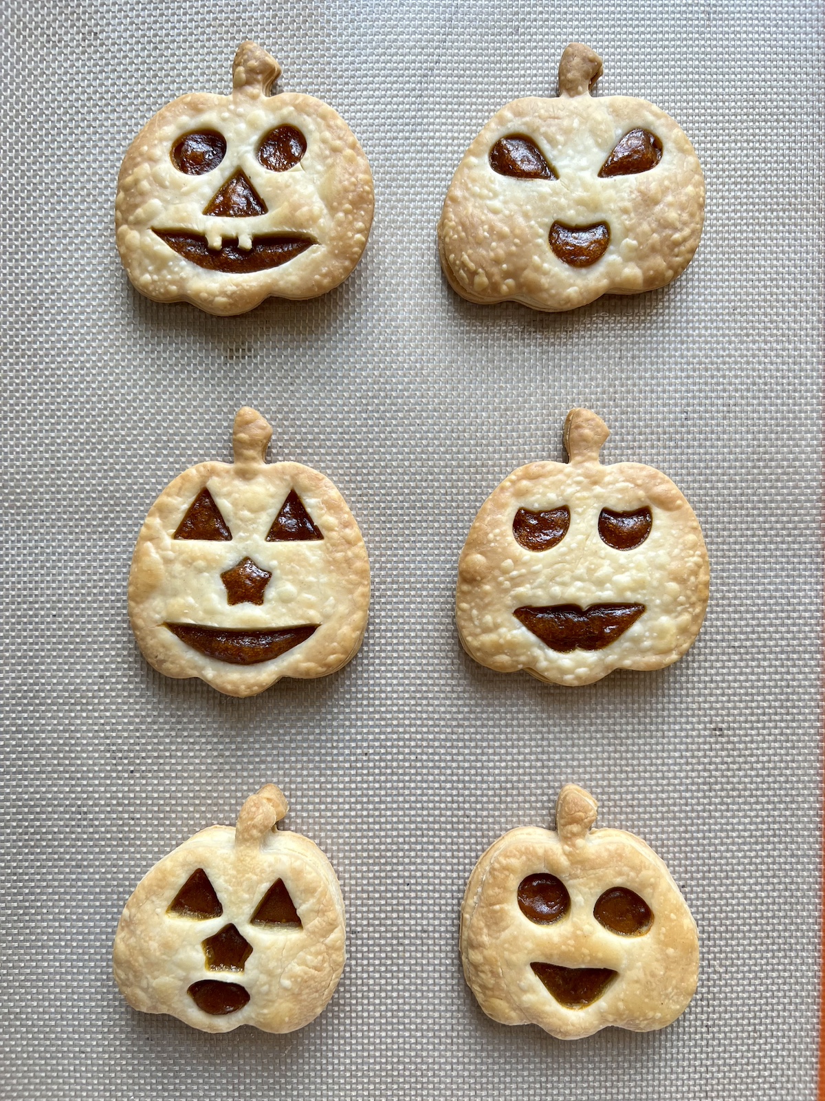 Baked pumpkin pie pop tarts on baking sheet.